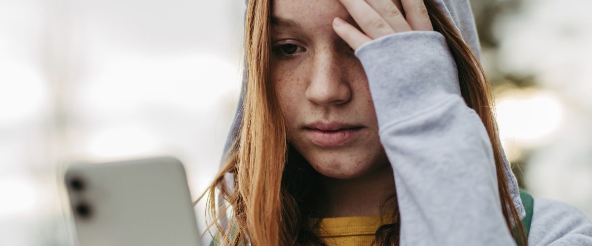 Anxious teenager looking at her smartphone