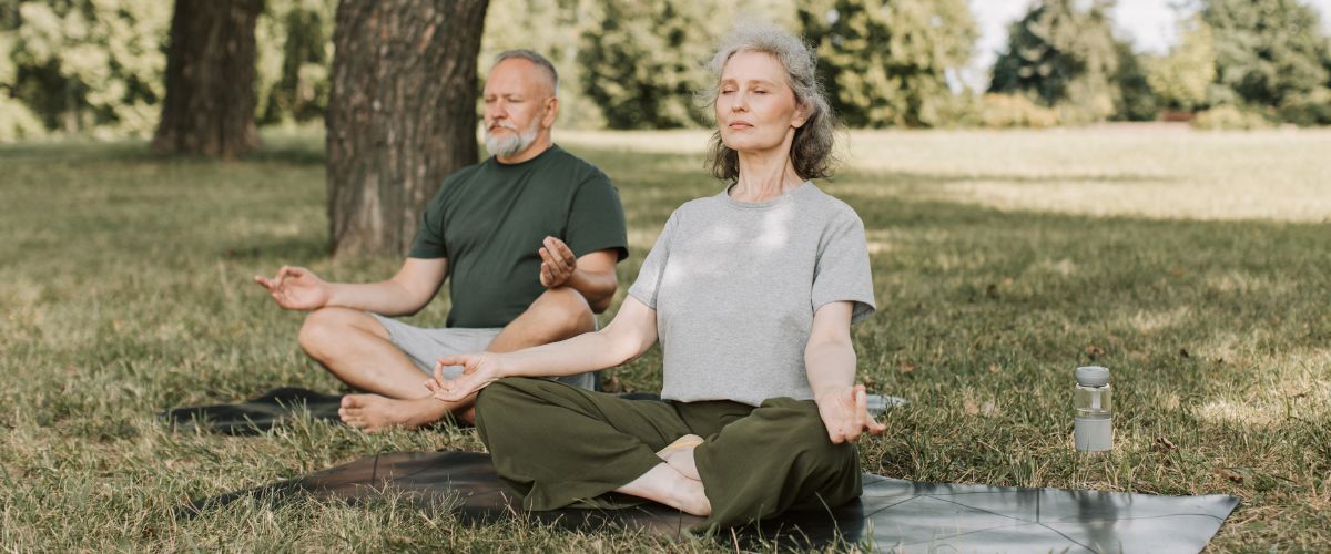 An elderly couple meditating
