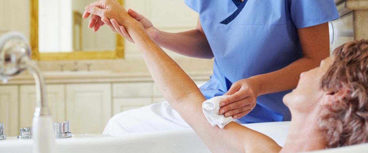 Nurse giving sponge bath to patient